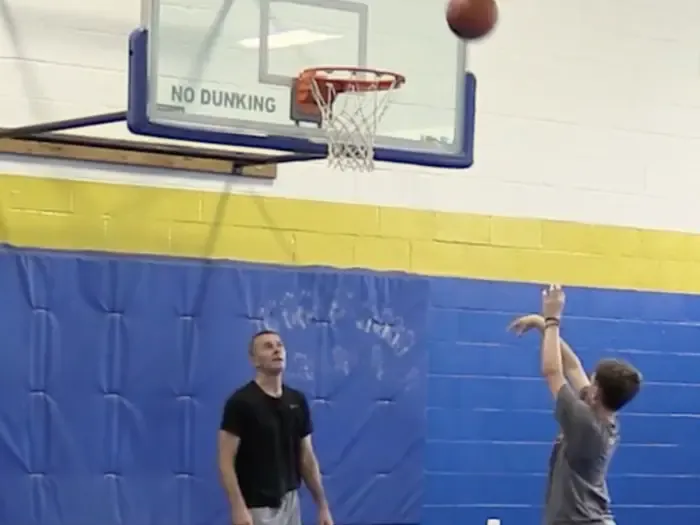 Coach watching a player work on shooting form