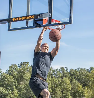 Man hanging from hoop after dunking