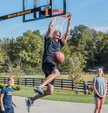 Man hanging from hoop after dunking